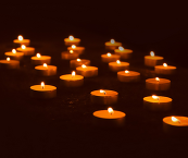 Tea candles lit up in a dark room