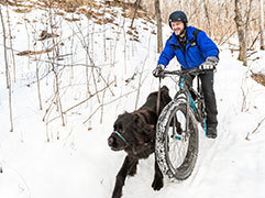 Man fat biking with his dog