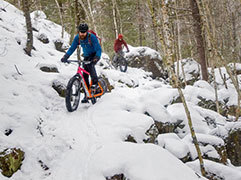 Two fat bikers navigate a snow-covered singletrack trail at Cuyuna