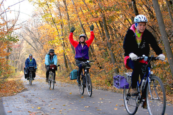 group of bikers pedaling on a lush fall trail
