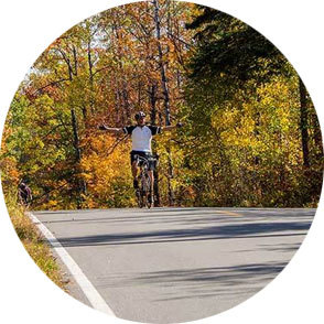 man extending his arms while biking