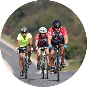 three bikers pedal up a hill
