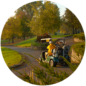 A view of a golfer and golf cart surrounded by colorful trees