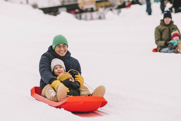 Father and daughter sledding at The Great Northern