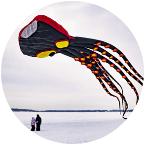 image of kids flying a kite over a frozen lake