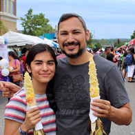 an image of a father and daughter with corn on the cob at Fiesta Latina