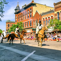 an image of people on horses in a bank raid reenactment