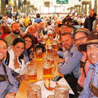 an image of people at a table with steins of beer during Oktoberfestival
