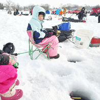 an image of a young girls and others ice fishing