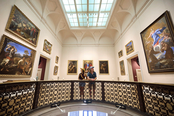 an image of Chereen Leong Schwarz and Rob Schwarz looking at large historic paintings at the Minneapolis Institute of Art