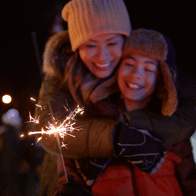 an image of a women and child with sparklers at night