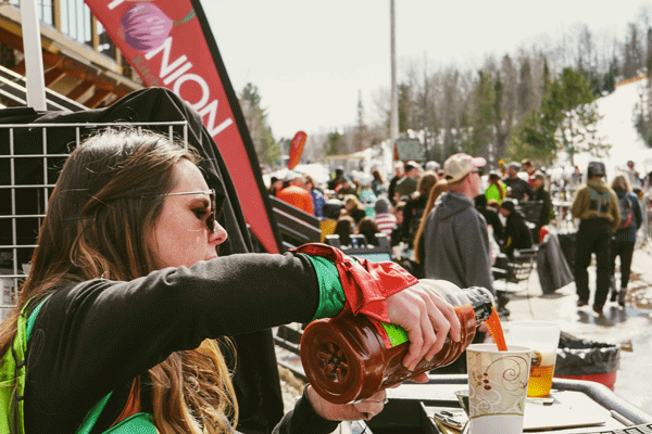 an image of people walking along a luminary lit trail under the northern lights