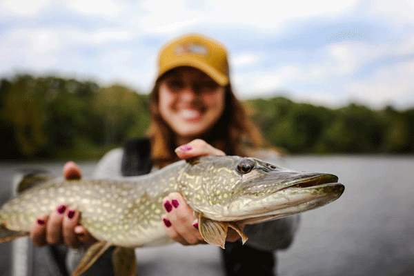  an image of a woman holding a northern pike
