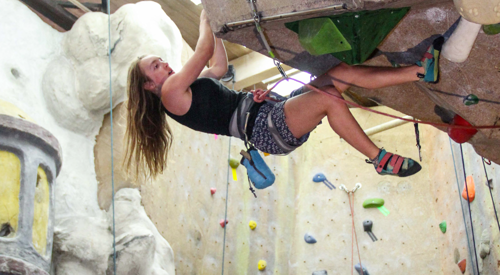 Person rock climbing indoors at Vertical Endeavors in Duluth