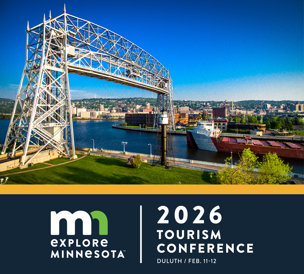 explore minnesota | 2026 Tourism Conference | Duluth | February 11-12 | photo of Duluth's lift bridge raised as a boat glides through