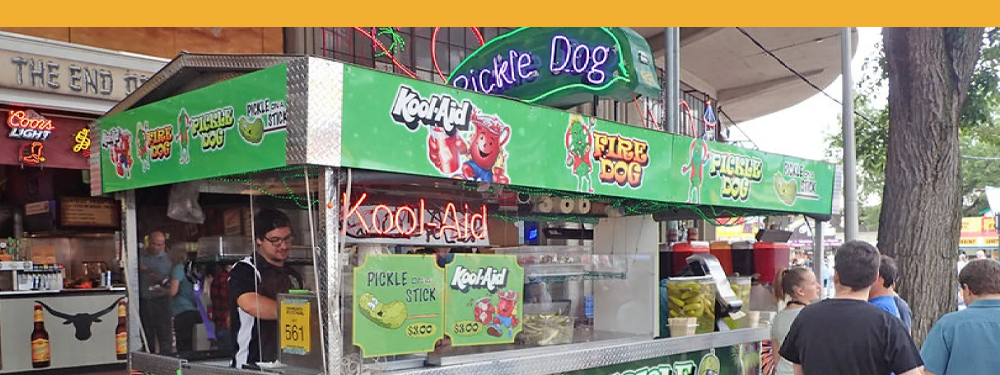 Kelly green food stand named "Pickle Dog." Images of the red Kool-Aid man and green pickles are featured on the Kelly Green banner.