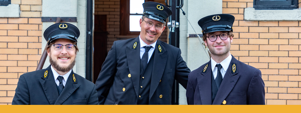 Hayes and 2 co-workers wear their official U.S. Lighthouse Service hat, navy-blue double-breasted coat, vest, and trousers.