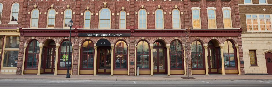historic red brick building with 4 arched doorways and 8 arched window on street level