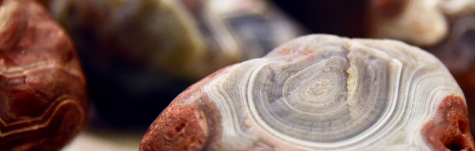 a closeup of a reddish-brown agate with white and grey swirls