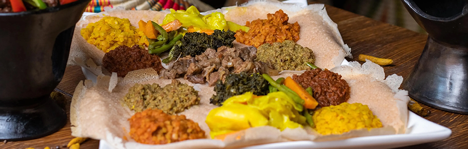 a square plate with a variety of meats and sides.