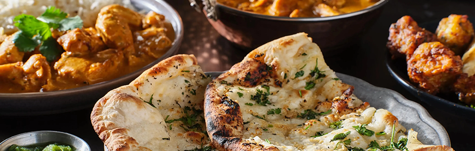 seasoned naan bread set next to several curries