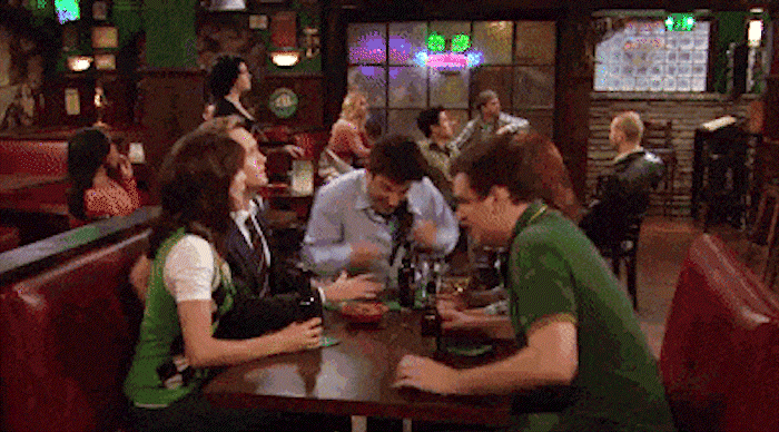 How I Met Your Mother gif of the crew cheering in their usual booth at their usual bar.
