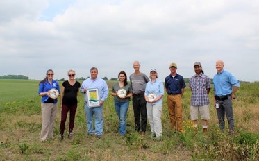 Lt. Governor Flanagan stands in field with other event attendees 