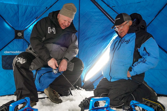 Governor Walz laughs while he is ice fishing with a friend.