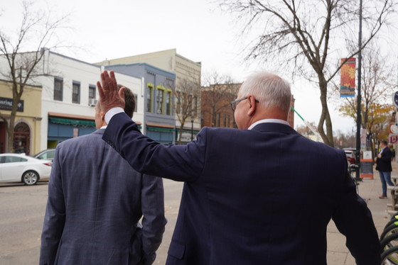 Governor Walz walks down sidewalk in small Minnesota town 