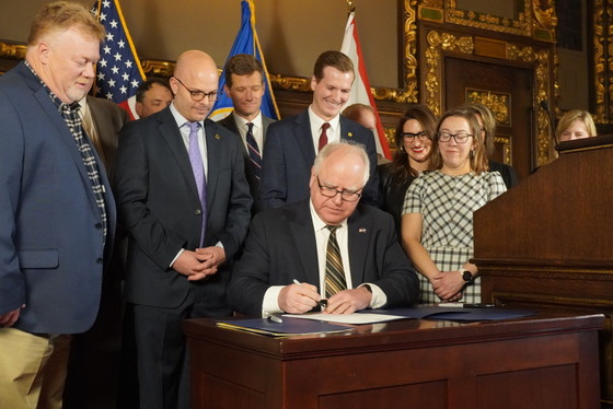 Governor Walz signs bill surrounded by advocates