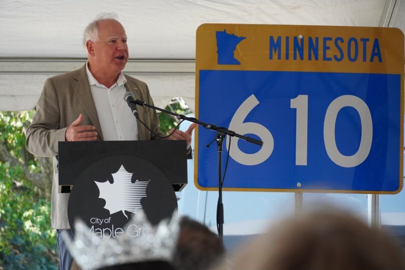 Governor Walz speaks next to Highway 610 sign 