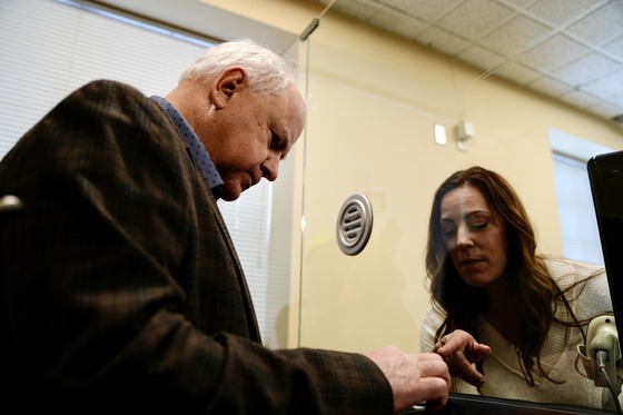 Governor Walz swipes his card at the White Bear Lake DVS to purchase his new specialty license plate.