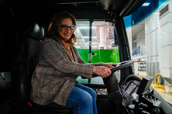 Lieutenant Governor Flanagan poses at the driver's seat of a New Flyer bus