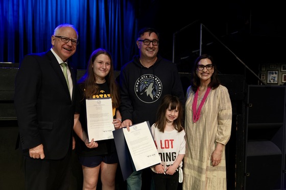 Governor Walz and Lieutenant Governor Flanagan pose with a family affected by high ticket fees