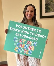 CEO visiting East Side Learning Center holding sign
