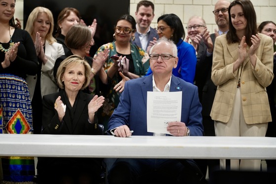 Governor Walz signs an executive order surrounded by community leaders