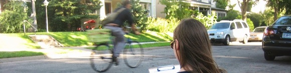 A volunteer counts a bicycle as it passes by
