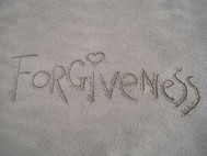 Image of the word Forgiveness written in sand
