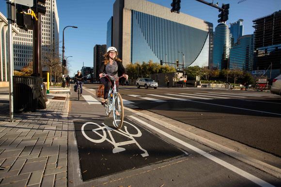 Woman riding bike on Washington Avenue cycle track near Hennepin Avenue