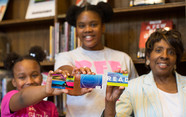 Adult and children with library cards