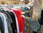 Browsing sweaters at a thrift store