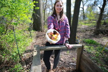 woman putting food scraps into backyard composting