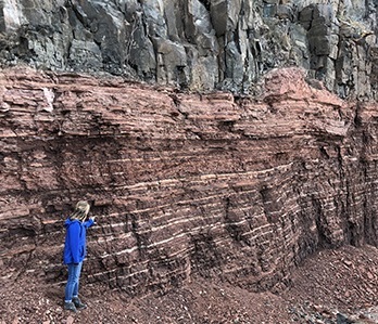 Woman standing by rocky wall