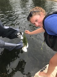 Woman pulling weed off of boat propeller