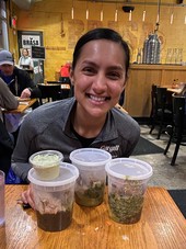 Woman with leftover food at restaurant packed in reusable containers