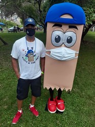 Person and Rusty the recycler standing together wearing masks
