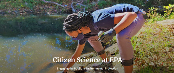 Citizen science participants takes water quality sample from a stream while wearing a mask