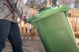 woman pushing green organics recycling cart