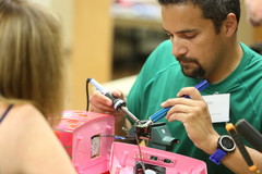 Fix-It Clinic volunteer holding tools working on a repair