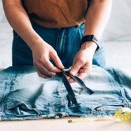 Person fixing zipper on jeans